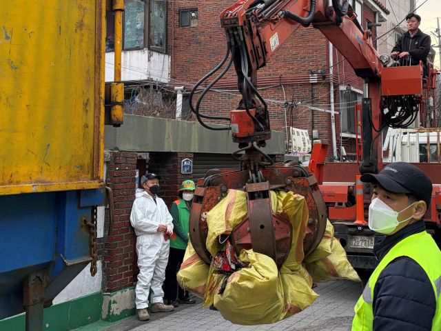 민관 합동 봉사자 40여 명은 산더미 처럼 쌓인 쓰레기를 정리했다. 안양시 제공