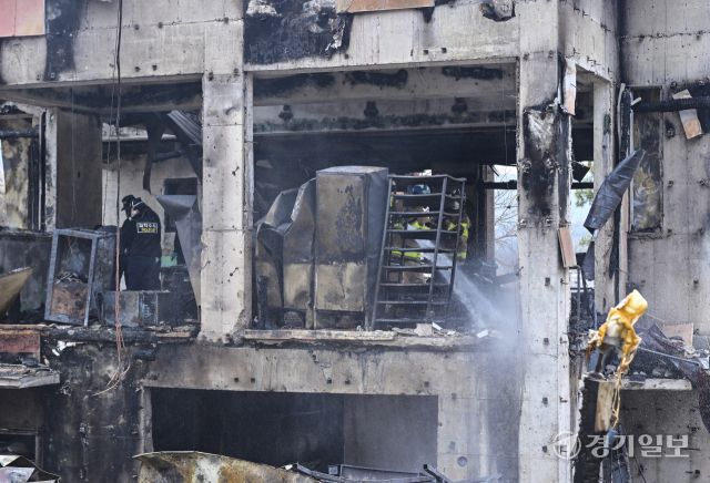 14일 오전 4시 42분쯤 과천시 과천동의 한 2층짜리 식당 건물에서 화재가 발생해 옥탑층 숙소에 있던 식당 종업원 2명이 숨졌다. 소방당국은 장비 20여 대와 인력 70여 명을 투입해 약 2시간 만인 오전 6시 46분께 불을 완전히 진화했다. 사진은 이날 오전 경찰과 소방당국이 현장에서 잔불 정리와 합동 감식을 진행하고 있는 모습. 홍기웅기자