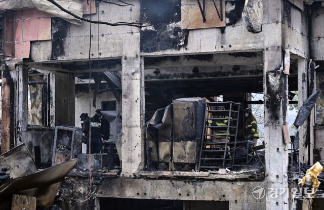 14일 오전 4시 42분쯤 과천시 과천동의 한 2층짜리 식당 건물에서 화재가 발생해 옥탑층 숙소에 있던 식당 종업원 2명이 숨졌다. 소방당국은 장비 20여 대와 인력 70여 명을 투입해 약 2시간 만인 오전 6시 46분께 불을 완전히 진화했다. 사진은 이날 오전 경찰과 소방당국이 현장에서 잔불 정리와 합동 감식을 진행하고 있는 모습. 홍기웅기자