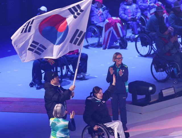 16일(한국시간) 이탈리아 코르티나 컬링 올림픽 스타디움에서 열린 2026 밀라노·코르티나담페초 동계 패럴림픽 폐막식에서 대한민국 선수단 기수 백혜진(경기도장애인체육회)과 이재혁이 입장하고 있다.연합뉴스
