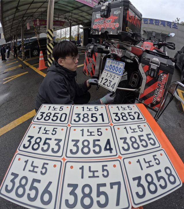 8일 수원특례시 권선구 수원도로교통관리사업소 번호판제작소 앞에서 직원이 새 이륜자동차 번호판 설치를 시연하고 있다. 국토교통부가 추진하는 ‘이륜자동차 번호판 개선 개정안’에 따라 내년 3월 20일부터 번호판 체계가 전면 개편된다. 기존처럼 시·도 등 지역명이 표기되던 방식에서 벗어나 전국 단일번호 체계로 변경된다. 또한 위·변조 및 번호판 가림 행위를 방지하기 위해 반사필름과 홀로그램 등 보안 요소가 강화되고 단속용 무인카메라 인식률을 높이기 위한 글자체와 배열도 개선된다. 번호판 크기는 기존 210㎜×115㎜에서 210㎜×150㎜로 확대돼 가독성이 높아질 전망이다. 이번 개정안은 배달 수요 증가 등으로 급증한 이륜자동차의 교통법규 위반과 범죄 악용 사례에 대응하기 위한 것으로 정부는 신규 등록 차량부터 적용하고 기존 차량은 일정 유예기간을 거쳐 단계적으로 교체를 유도할 계획이다.조주현기자