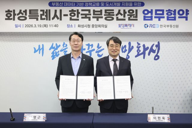 정명근 화성특례시장(왼쪽)이 이헌욱 한국부동산원장과 업무협약을 마친 뒤 기념촬영을 하고 있다. 화성특례시 제공