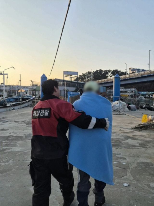 영흥파출소 경찰관이 저체온증을 호소하는 A씨를 소방 본부에 인계하고 있다. 인천해양경찰서 제공