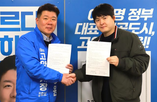 최승원 고양시장 예비후보 선거 사무실에서 최 예비후보와 김동석 정발마을 2·3단지 재건축 추진위원장이 정책 협약서에 서명하고 악수를 나누고 있다. 최승원 고양시장 예비후보 선거 사무실 제공