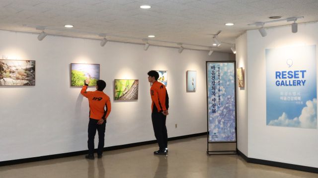 화성소방서 직원들이 ‘마음건강: RESET’ 사진전을 관람하고 있다. 화성소방서 제공