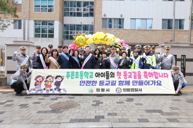 푸른초등학교 개교를 맞아 실시된 교통안전 캠페인에 참여한 기관장과 학부모들이 파이팅을 외치고 있다. 의왕시 제공