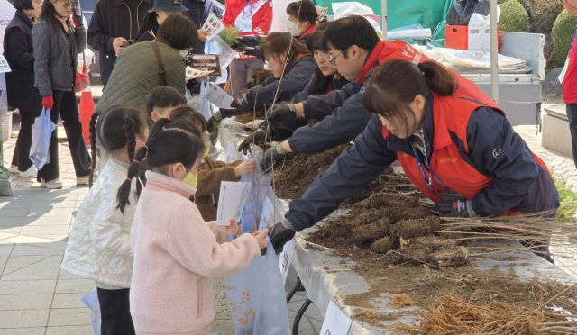 포천체육공원에서 열린 ‘내 나무 갖기 캠페인’에서 봉사자들이 아이들에게 묘목을 나눠주고 있다. 포천시 제공