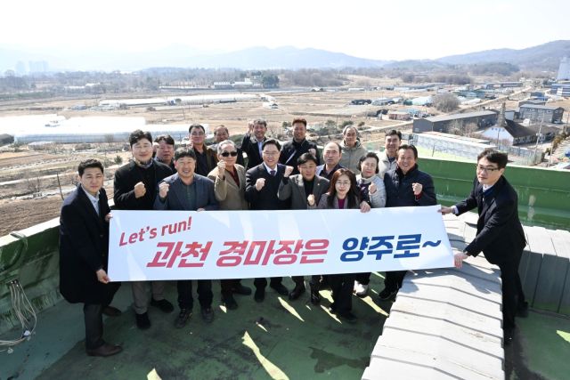 강수현 양주시장과 광적면 주민 대표 등이 양주시 광적면 행정복지센터 옥상에서 사업 대상부를 배경으로 ‘과천 경마공원 유치’ 문구가 적힌 플래카드를 들고 결의를 다지고 있다. 양주시 제공