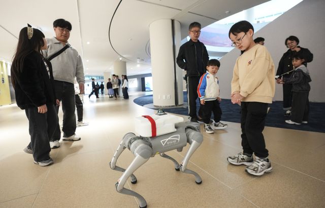 11일 수원특례시 영통구 경기도서관에서 열린 인공지능 로봇 체험전 ‘로봇을 이겨라!’에서 어린이들이 4족 보행 로봇인 댕댕로봇을 신기해하고 있다. 이번 행사는 경기도서관에 지하1층부터 4층까지 각 층에 배치된 피지컬 AI 로봇을 시민이 직접 체험하는 행사로 진행됐다. 홍기웅기자