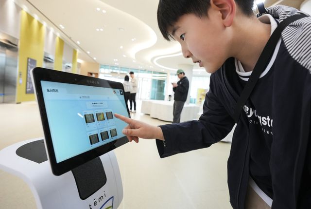 11일 수원특례시 영통구 경기도서관에서 열린 인공지능 로봇 체험전 ‘로봇을 이겨라!’에서 한 어린이가 안내 로봇 테미를 통해 도서 퀴즈를 진행하고 있다. 이번 행사는 경기도서관에 지하1층부터 4층까지 각 층에 배치된 피지컬 AI 로봇을 시민이 직접 체험하는 행사로 진행됐다. 홍기웅기자