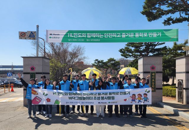 HL만도(주) 임직원들이 지난 9일 평택 내기초등학교에서 학생들과 함께 통학로 개선을 위한 바닥그림놀이터 봉사활동에 참여했다. 초록우산 경기1지역본부 제공