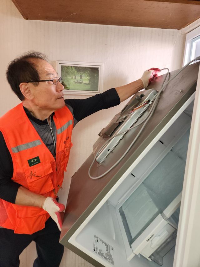 최문희 전 회장이 이삿짐을 옮기고 있다. 2424봉사단 제공