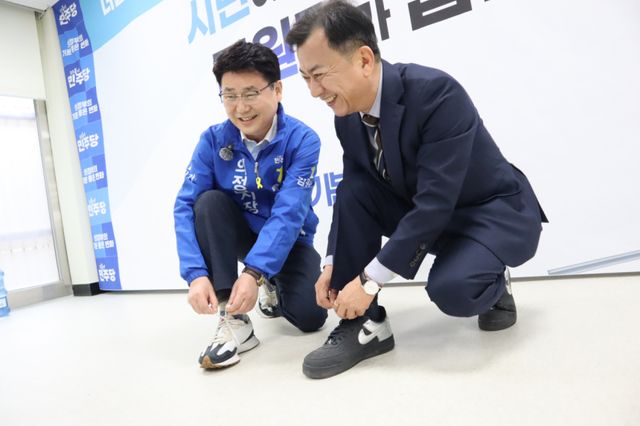 김원기 더불어민주당 의정부시장 예비후보와 심화섭 전 예비후보가 15일 정책협력을 선언한 뒤 운동화 끈을 동여 매고 있다. 김원기 의정부시장 예비후보 선거 캠프 제공