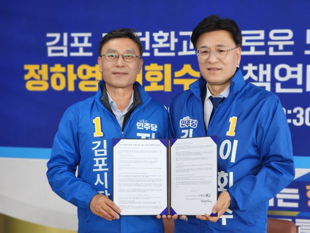 정하영 예비후보(왼쪽)와 이회수 예비후보가 정책연대에 합의한 뒤 기념사진을 찍고 있다. 양형찬 기자