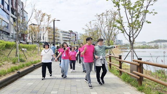 17일 열린 시흥시 은계호수공원에서 열린 ‘거북이 걷기대회’에 참가한 장애인과 비장애인들이 서로 손을 잡고 걷고 있다. 시흥시 제공