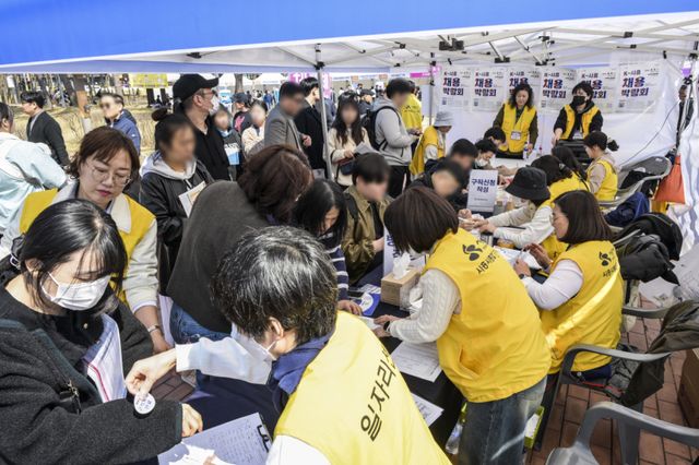 2일 오후 시흥시 능곡동 중앙공원에서 열린 'K-시흥 채용박람회'를 찾은 구직자들이 구직 활동을 벌이고 있다. 이날 박람회에서는 50여 개의 업체가 참여했다. 윤원규기자