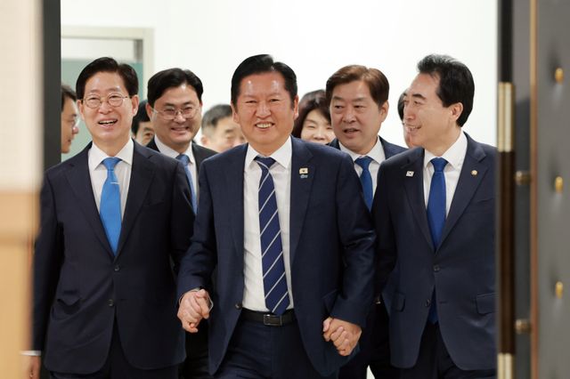 더불어민주당 정청래 대표가 20일 충남 보령머드테마파크에서 열린 현장 최고위원회의에 박수현 충남도지사 후보, 박 후보와 경선을 치른 양승조 전 충남도지사와 손을 잡고 참석하고 있다. 연합뉴스