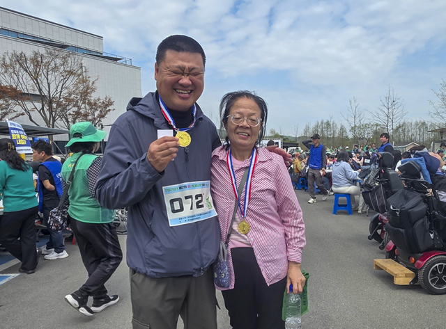 핸디마라톤 대회 참가자가 완주 후 메달을 목에 걸고 기뻐하고 있다. 독자 제공