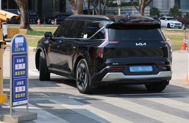 서울 종로구 정부서울청사 입구에 차량 5부제 실시 안내문 옆을 전기차가 지나가고 있다. 연합뉴스