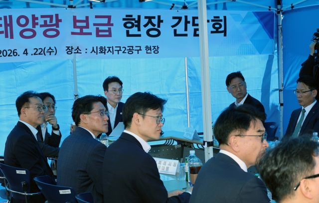 김민석 국무총리가 22일 경기도 화성시 시화지구 태양광 보급 현장 시찰을 마친 뒤 향후 계획 등에 대해 보고받고 있다. 연합뉴스