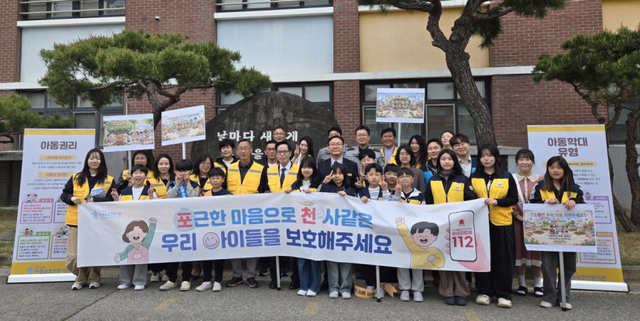 포천 추산초등학교 앞에서 포천아동보호전문기관 관계자들이 ‘포근한 마음으로 천사 같은 우리 아이들을 보호해 주세요’ 문구가 적힌 현수막을 들고 아동학대 예방 캠페인을 펼치고 있다. 포천시 제공