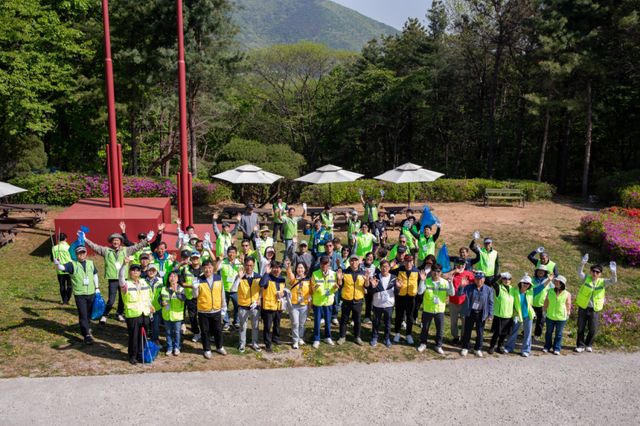 김포경찰서 생활안전연합회 회원들이 환경정화 활동을 펼치며 사진촬영 드론을 향해 화이팅을 외치고 있다. 김포경찰서 생활안전연합회 제공