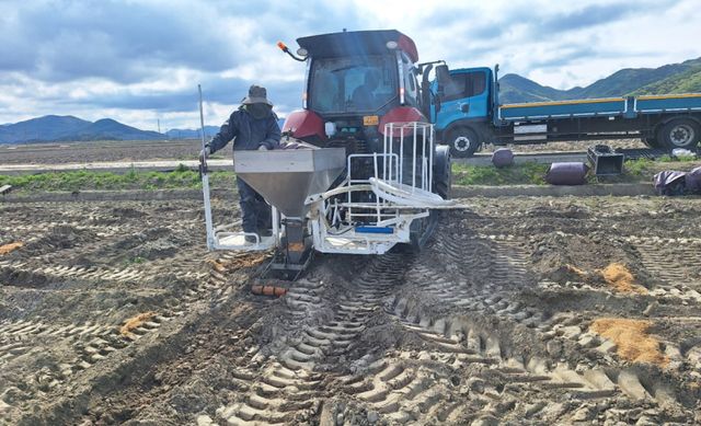 삼산면 석모리에서 매설장비를 부착한 트랙터로 ‘왕겨 충진형 땅속배수 기술’을 적용한 논콩 재배 시범사업을 진행하고 있다. 농업기술센터 제공.