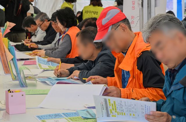 29일 오후 수원특례시 팔달구 화성행궁 광장에서 열린 ‘수원시 노인일자리 채용한마당’에서 장년·노년층 구직자들이 취업신청서 및 이력서를 작성하고 있다. 김시범기자