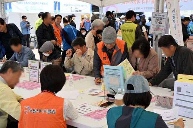 29일 오후 수원특례시 팔달구 화성행궁 광장에서 열린 ‘수원시 노인일자리 채용한마당’에서 장년·노년층 구직자들이 취업신청서 및 이력서를 작성하고 있다. 김시범기자