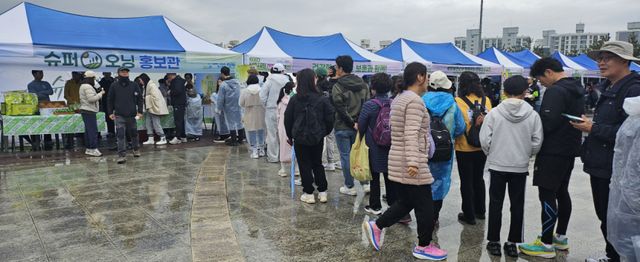 4일 오전 평택 이충레포츠공원에서 열린 ‘2026 평택시민건강걷기대회’에서 평택 농산물 브랜드 가치를 높이기 위한 ‘슈퍼오닝’ 부스가 문전성시를 이루고 있다. 윤동현기자