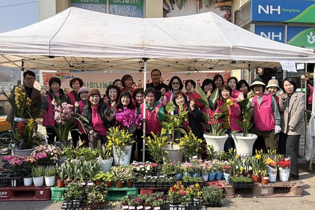 인천 옹진군 북도면 농가주부모임이 최근 마련한 ‘봄꽃 판매행사’에서 기념사진을 촬영하고 있다. 옹진군 제공