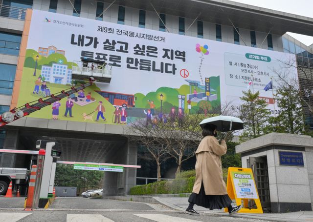 제9회 전국동시지방선거를 55일 앞둔 9일 오전 수원특례시 영통구 경기도선거관리위원회에서 관계자들이 투표 홍보 현수막을 설치하고 있다. 윤원규기자