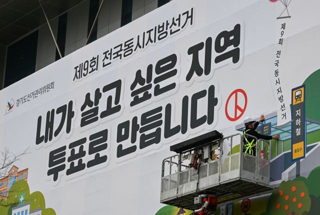 제9회 전국동시지방선거를 55일 앞둔 9일 오전 수원특례시 영통구 경기도선거관리위원회에서 관계자들이 투표 홍보 현수막을 설치하고 있다. 윤원규기자