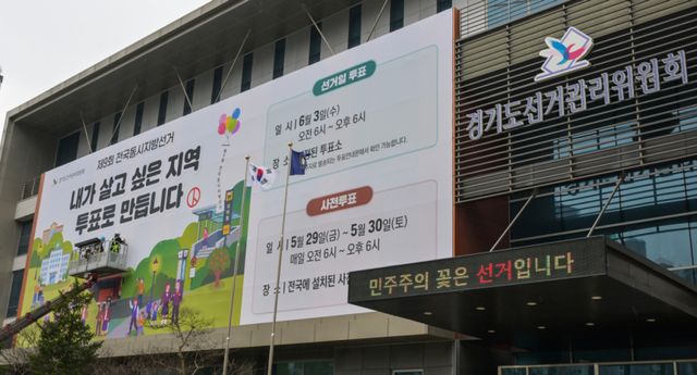 제9회 전국동시지방선거를 55일 앞둔 9일 오전 수원특례시 영통구 경기도선거관리위원회에서 관계자들이 투표 홍보 현수막을 설치하고 있다. 윤원규기자