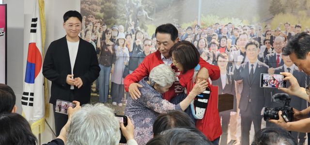 백영현 포천시장 후보가 90세 모친이 입혀준 선거운동복을 입고 가족들을 안아주고 있다. 손지영기자
