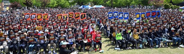 10일 인천시청에서 열린 ‘인천국제공항 통합 반대 인천시민 총궐기대회’에서 참여자들이 손피켓을 들어보이며 사진을 촬영하고 있다. 조병석기자