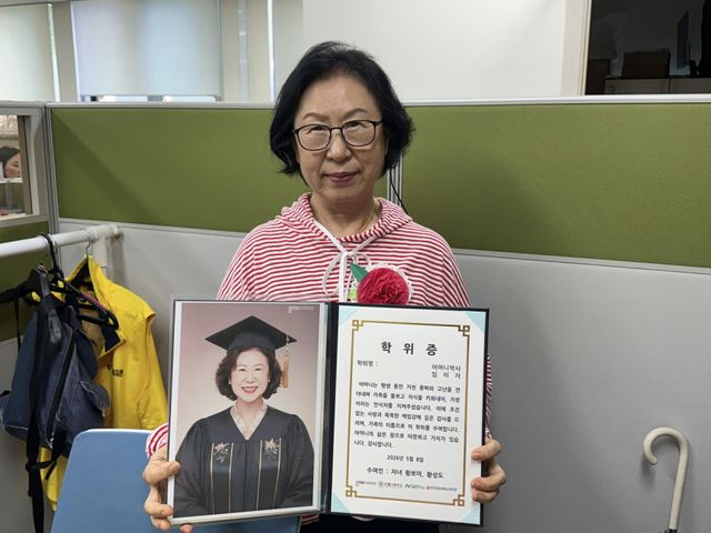 경기콘텐츠진흥원의 ‘따뜻한 서사, 인생 학위 헌정 프로젝트’를 통해 어머니박사 학위를 받은 임미자씨가 학위증을 든 채 환한 미소를 짓고 있다. 경기콘텐츠진흥원 제공