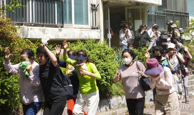 14일 수원특례시 권선구 현대아파트 재개발 단지에서 열린 '2026 재난대응 안전한국훈련'에서 주민들이 대피 훈련을 진행하고 있다. 이날 훈련은 침수, 화재 등 각종 재난 상황을 가정해 인명 구조와 현장 대응 능력을 점검하는 방식으로 진행됐다. 홍기웅기자