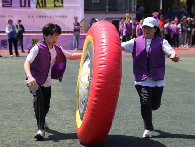16일 ‘제43회 월미체전’에서 청소년교육복지상담학과 학생(오른쪽)과 청소년(왼쪽)이 함께 풍선 타이어를 굴리는 ‘협동 달리기’ 게임을 하고 있다. 한국방송통신대 인천지역대학 제공