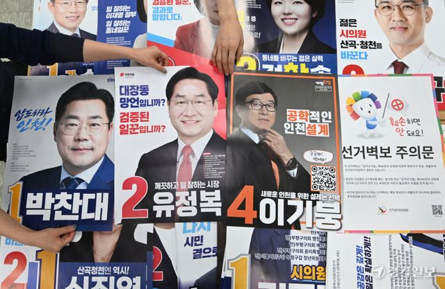 6·3 전국동시지방선거 공식 선거운동을 하루 앞둔 20일 인천 부평구 선거관리위원회에서 선관위 직원들이 인천시장 후보들이 제출한 선거 벽보 점검하고 있다.조병석기자