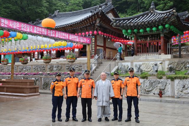 이정용 의왕소방서장(왼쪽 세번째)과 대원들이 부처님 오신날에 대비해 청계사에서 현장 안전 지도점검을 실시한 뒤 성행 주지스님과 기념사진을 찍고 있다. 의왕소방서 제공
