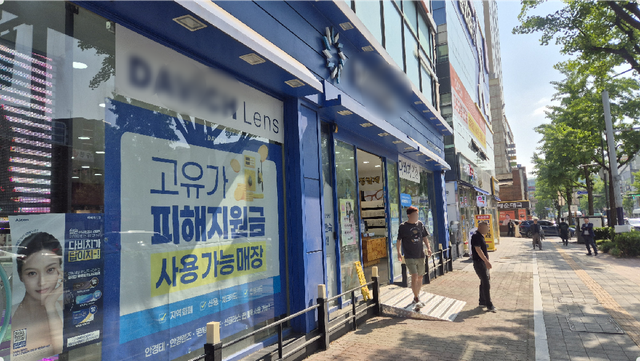 23일 수원역 인근 안경원 벽면에 ‘고유가 피해지원금’ 사용 가능 매장임을 알리는 포스터가 부착돼 있다. 금유진기자