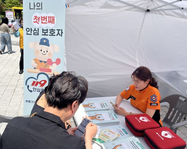 양주소방서 구급팀 대원이 홍보부스를 찾은 외국인 주민에게 119 안심콜 서비스 가입을 도와주고 있다. 양주소방서 제공