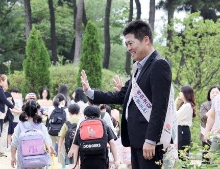 인천 영종구청장 선거에 출마한 국민의힘 김정헌 후보가 등교하는 어린이들을 향해 인사하고 있다. 김정헌 캠프 제공