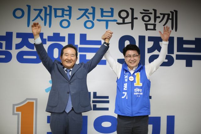 정세균 전 국무총리와 김원기 의정부시장 후보가 지난 26일 선거사무소에서 손을 들어 올리고 있다. 김원기 후보 캠프 제공