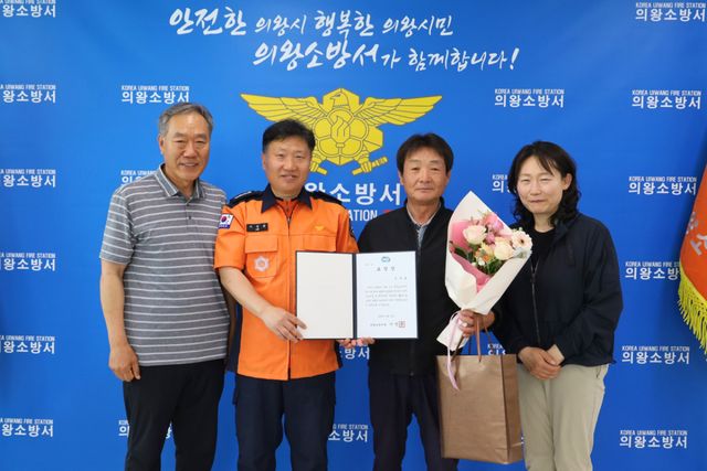 이정용 의왕소방서장(왼쪽 두 번째)이 김경호씨(왼쪽 세 번째)에게 표창장을 전달한 뒤 기념촬영을 하고 있다. 의왕소방서 제공