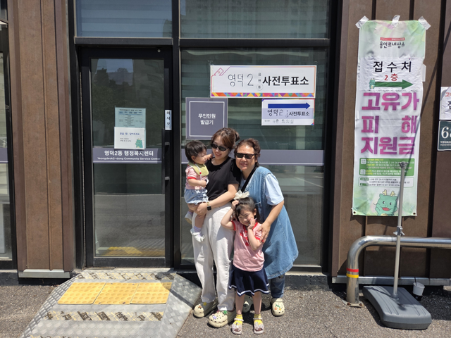 홍미경씨(62)가 안유진씨(35), 두 손주와 함께 29일 용인시 영덕2동 행정복지센터 사전투표소에서 투표를 마치고 포즈를 취하고 있다. 부석우기자