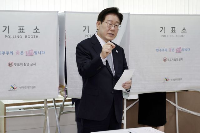 이재명 대통령이 제9회 전국동시지방선거 사전투표 첫날인 29일 서울 종로구 삼청동 주민센터에서 사전 투표 중 기표 도장 관련 문의를 하고 있다. 연합뉴스