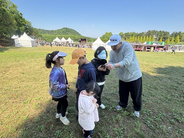 연천 구석기 축제에 방문한 노승환씨(40)가 네 남매를 데리고 잔디밭 위에서 ‘연천 구석기 트레저’를 즐기고 있다. 서다희 기자