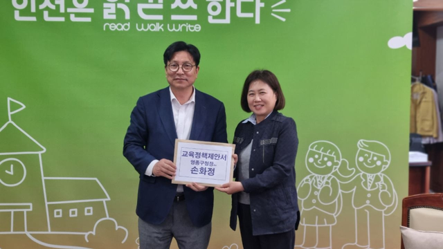 손화정 더불어민주당 인천 영종구청장 예비후보가 도성훈 인천시 교육감에게 영종 지역 교육 혁신 관련 정책 제안서를 전달하며 기념촬영을 하고 있다. 손화정 후보 캠프 제공